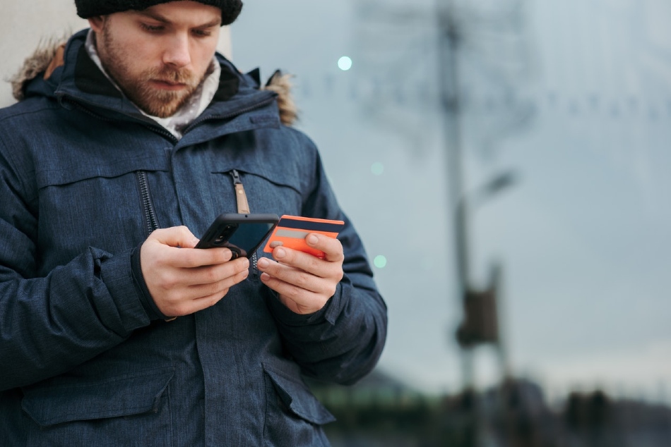 Australian man in beanie and jacket buying modafinil online using his phone